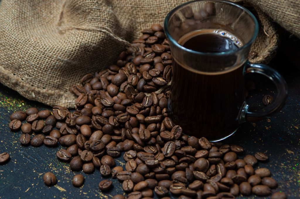 dark roast coffee beans next to filter coffee